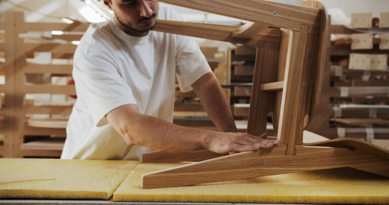Person working on a wooden chair in an atelier